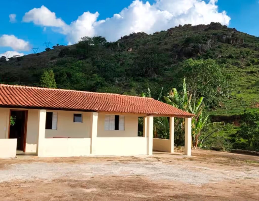 Pousada rústica em Albertina-MG rodeada por montanhas e natureza.